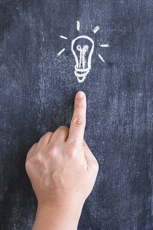 person-pointing-finger-on-drawn-light-bulb
